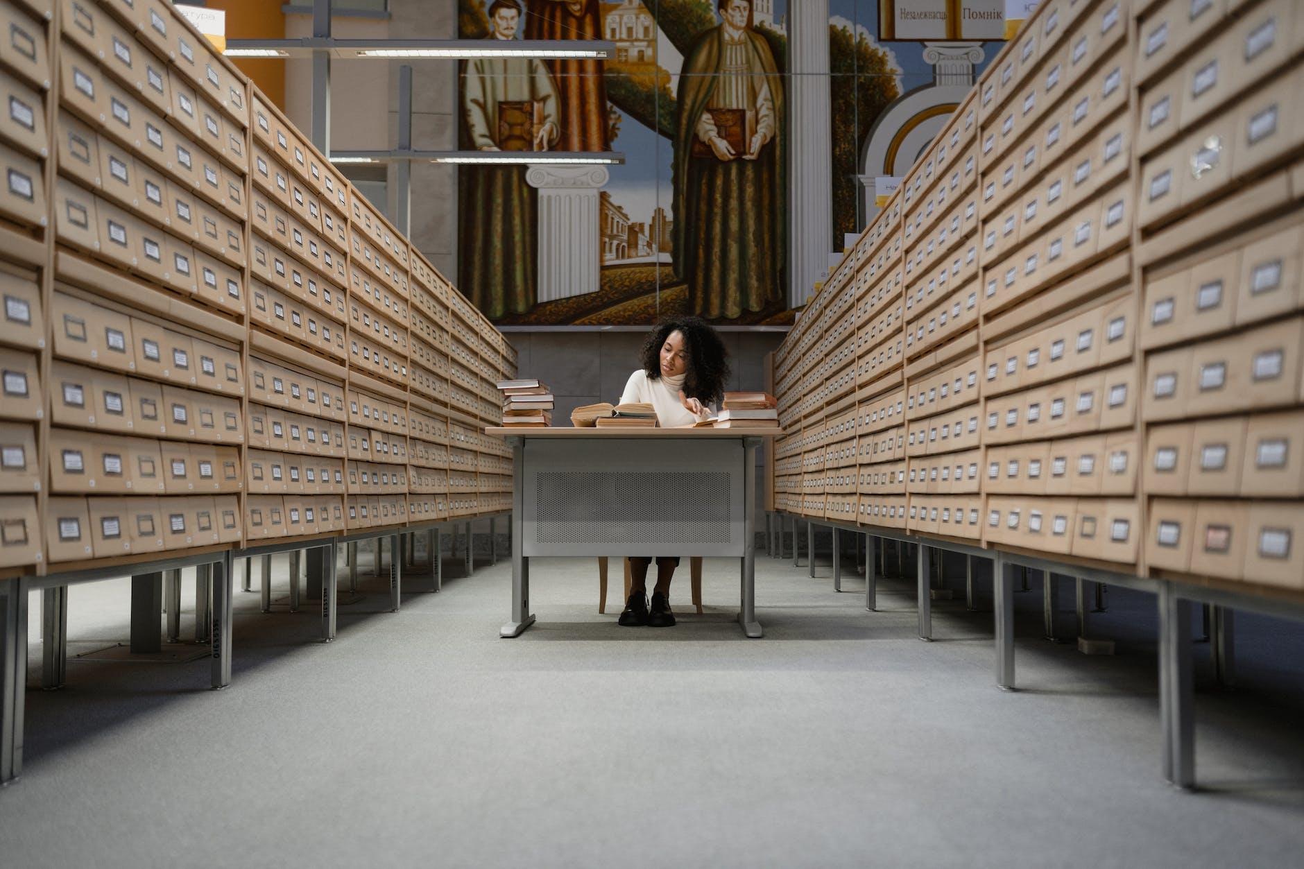 a woman sitting at a desk in a library